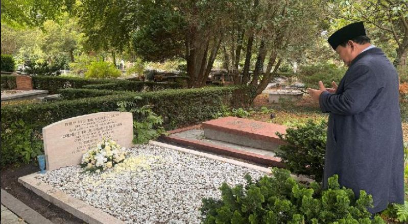 Prabowo Subianto berdiri dengan kedua tangan terangkat berdoa di depan nisan bertuliskan Philip Frederik Laurens Sigar dan Cornelie Emelie Maengkom, di pemakaman Oud Eik en Duinen, Den Haag.